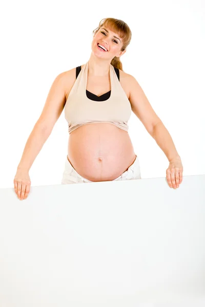 Ευτυχής όμορφη έγκυο γυναίκα, κρατώντας πινακίδα κενό — Φωτογραφία Αρχείου