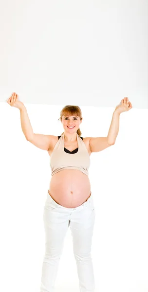 ブランクの看板を持って笑顔の美しい妊娠中の女性 — ストック写真