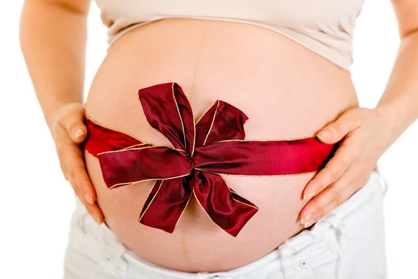 Έγκυος γυναίκα με κόκκινη κορδέλα στην κοιλιά. κινηματογράφηση σε πρώτο πλάνο. — Φωτογραφία Αρχείου