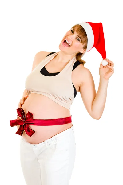 Счастливая красивая беременная женщина в шляпе Санты с красной лентой на животе — стоковое фото