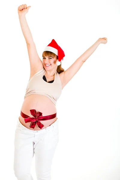 Счастливого Рождества беременная женщина в шляпе Санты поднимает руки вверх — стоковое фото