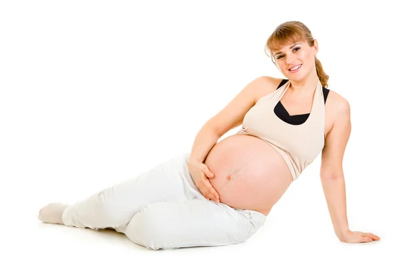 Katta oturan ve beline tutarak mutlu güzel hamile kadın — Stok fotoğraf