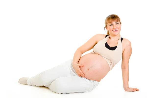 Drömmer vacker gravid kvinna sitter på golvet och hålla hennes mage — Stockfoto