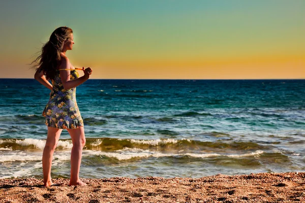 Vacker kvinna njuter av soluppgången på stranden — Stockfoto