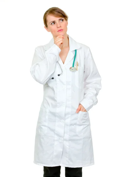 Médico pensativo mulher médica olhando para cima no espaço de cópia — Fotografia de Stock