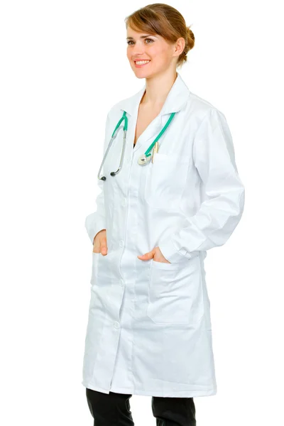 Médica sorridente com as mãos em bolsos de roupão — Fotografia de Stock