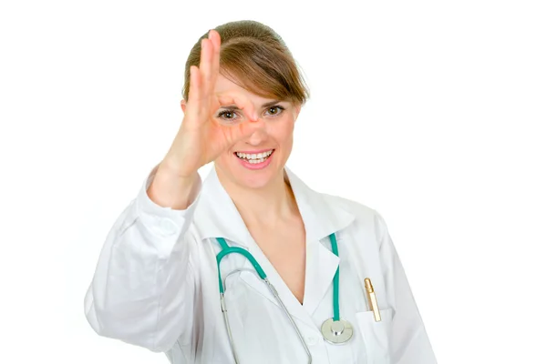 Sonriente médico mujer mirando a través de gesto ok — Foto de Stock