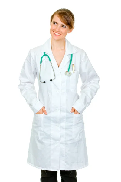 Médico sonriente mujer con las manos en los bolsillos de la bata — Foto de Stock