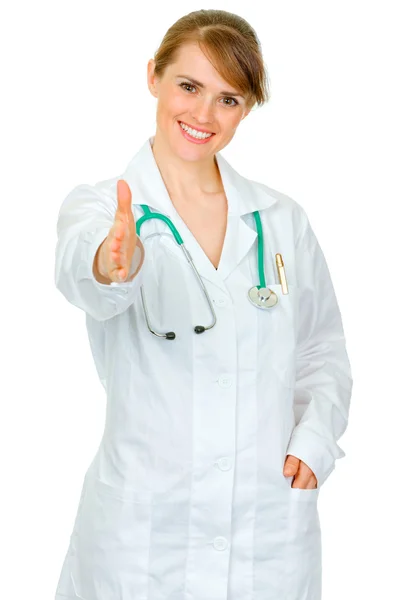 握手を求めて手を伸ばす医師女性の笑みを浮かべて — ストック写真