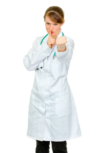 Médico irritado mulher com o dedo na boca e ameaçar com punho — Fotografia de Stock