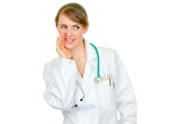 Médico sonriente mujer sosteniendo su mano cerca de la boca y secretamente repor —  Fotos de Stock