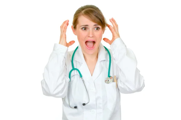 Шокированная женщина-врач держит руки возле головы — стоковое фото