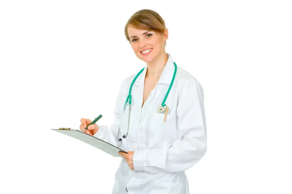 Sorridente medico donna prendere appunti nella cartella medica — Foto Stock