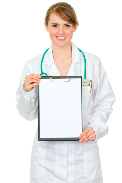 Médico sonriente mujer sosteniendo el portapapeles en blanco en las manos — Foto de Stock
