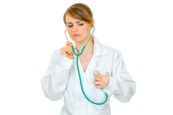 Konzentrierte Ärztin hört mit Stethoskop auf ihr Herz — Stockfoto