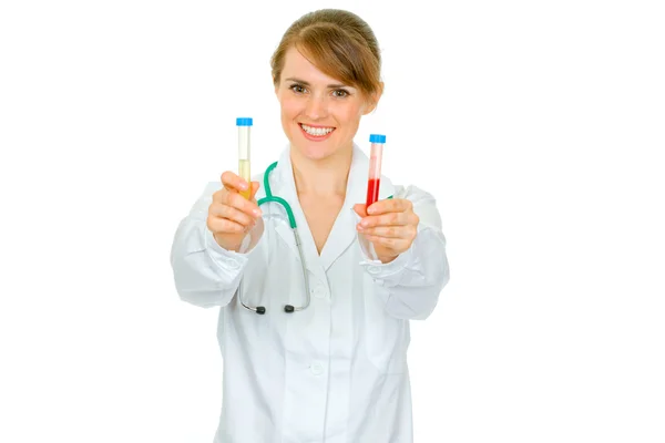 Médico sonriente mujer sosteniendo tubos de ensayo en la mano —  Fotos de Stock