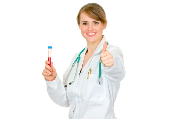 Médico mujer sosteniendo la muestra de sangre y mostrando los pulgares hacia arriba gesto —  Fotos de Stock