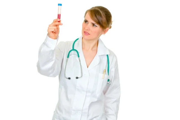 Médico médico pensativo mujer buscando en tubo de ensayo —  Fotos de Stock