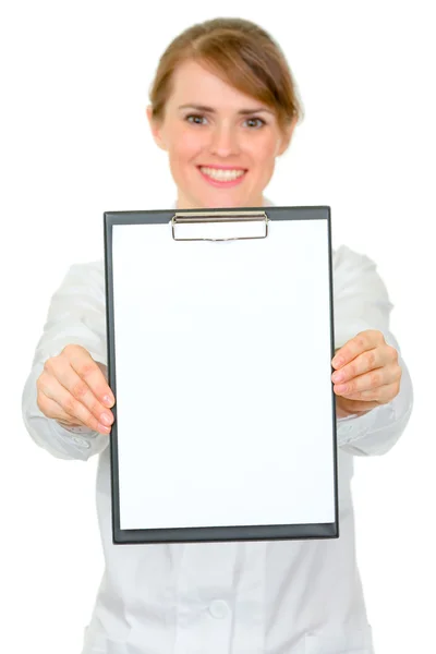 Smiling medical female doctor holding blank clipboard in hands — Stock Photo, Image