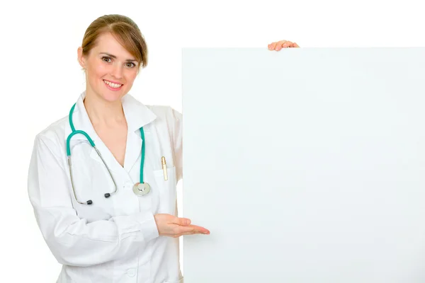 Médico sonriente mujer señalando en la cartelera en blanco —  Fotos de Stock