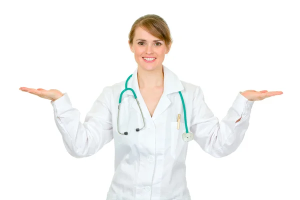 Улыбающаяся женщина-врач представляет что-то на пустых руках — стоковое фото