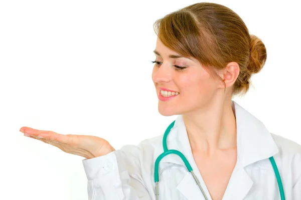Médica sorridente olhando na palma vazia — Fotografia de Stock