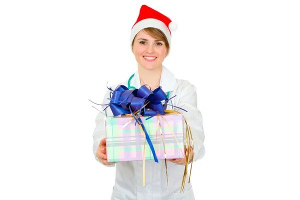 Sorrindo médico mulher em Santa chapéu segurando presente nas mãos — Fotografia de Stock