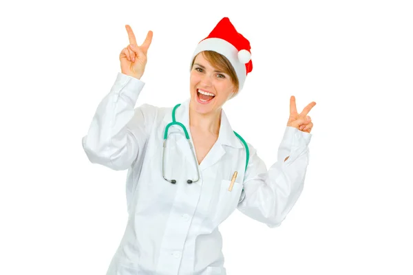 Ευτυχής ιατρός γυναίκα με καπέλο santa δείχνει νίκη χειρονομία — Φωτογραφία Αρχείου