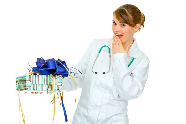 Förvånad läkare kvinna med närvarande i hand — Stockfoto