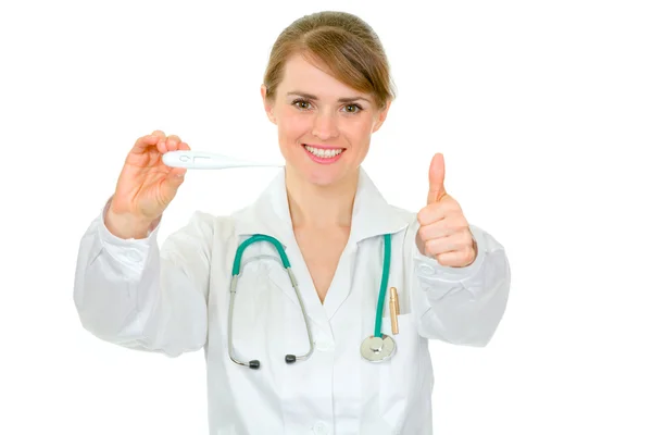 Médico mujer sosteniendo termómetro médico y mostrando los pulgares hacia arriba gesto —  Fotos de Stock