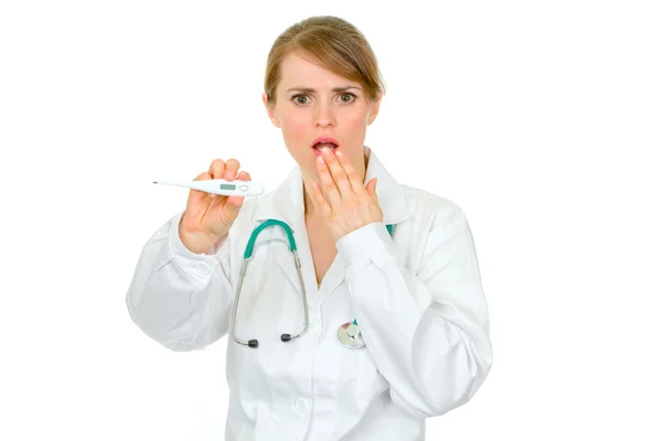 Doctora conmocionada sosteniendo termómetro médico en la mano —  Fotos de Stock