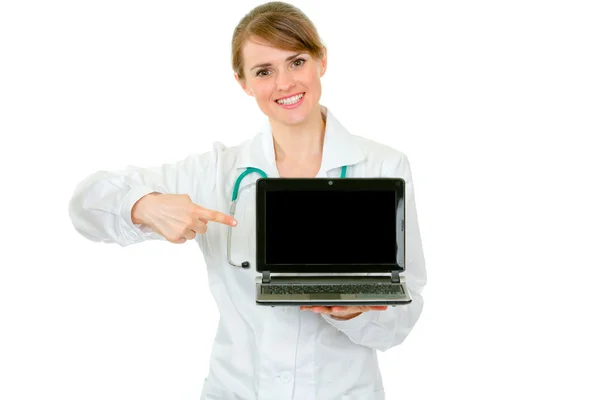 医師の女性が空白の画面とラップトップ上で指を指すの笑みを浮かべてください。 — ストック写真