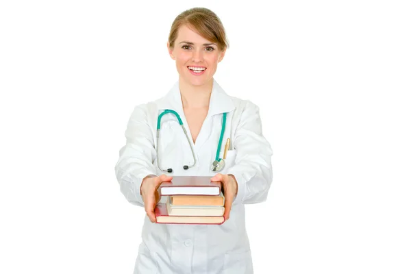 Lachende jonge vrouwelijke arts geven verschillende boeken — Stockfoto