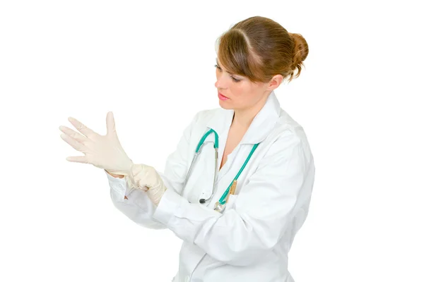 Médecin féminin concentré portant des gants médicaux en latex sur sa main — Photo