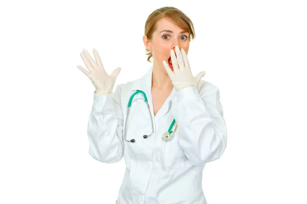 Geschokt vrouwelijke arts in medische handschoenen die hand in de buurt van mond — Stockfoto