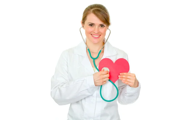 Happy medical female doctor holding stethoscope on paper heart — Stock Photo, Image
