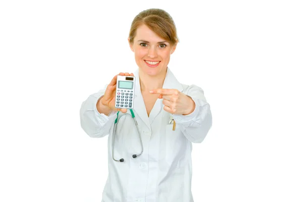 Uśmiechający się lekarza kobieta palcem wskazującym na kalkulator — Zdjęcie stockowe