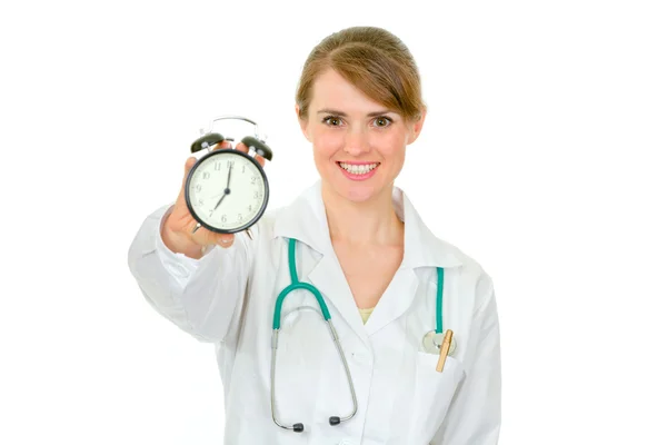 Médico sonriente con reloj despertador en la mano — Foto de Stock