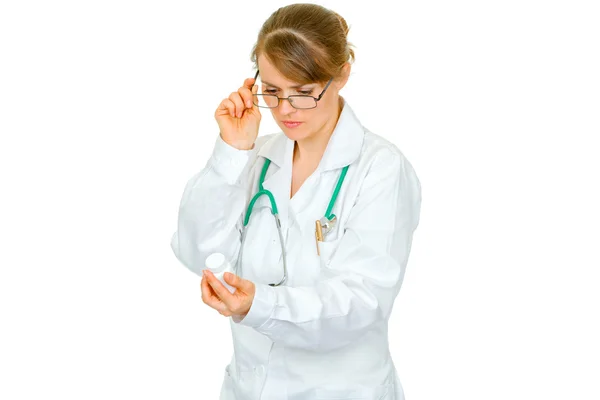 Концентрированная женщина-врач в очках, читающая название препарата — стоковое фото