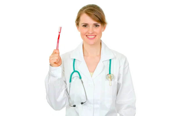 Smiling medical female doctor holding toothbrush — Stock Photo, Image