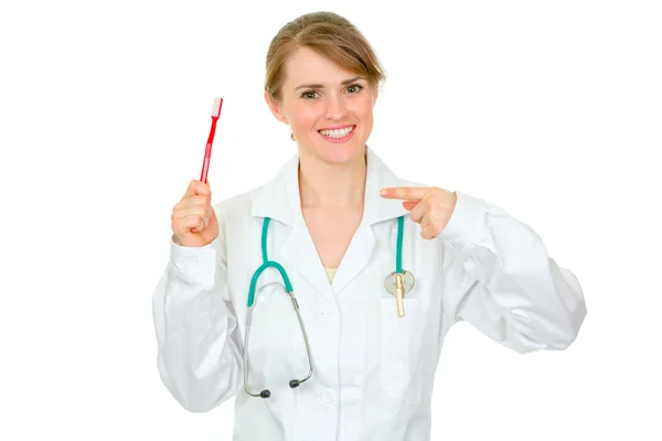 Lachende tandarts vrouwelijke wijzende vinger op tandenborstel — Stockfoto