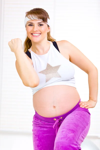 Uśmiechający się piękna kobieta w ciąży robi fitness ćwiczenia w domu — Zdjęcie stockowe
