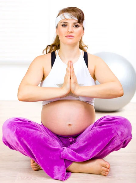 Piękna kobieta w ciąży robi ćwiczenia jogi, na piętrze w domu — Zdjęcie stockowe