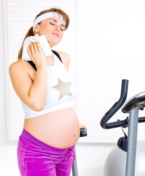 Piękna w ciąży kobieta szkolenia na rower treningowy — Zdjęcie stockowe