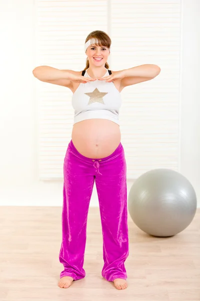 Gülümseyen güzel hamile kadın evde egzersiz yaparak — Stok fotoğraf