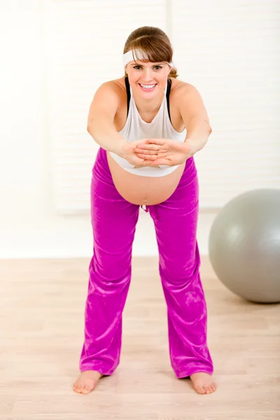 Sonriendo hermosa mujer embarazada haciendo gimnasia en casa —  Fotos de Stock