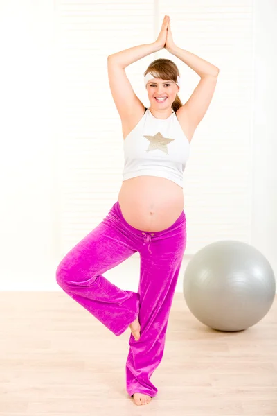 Sonriendo hermosa mujer embarazada haciendo ejercicios de pilates en casa —  Fotos de Stock