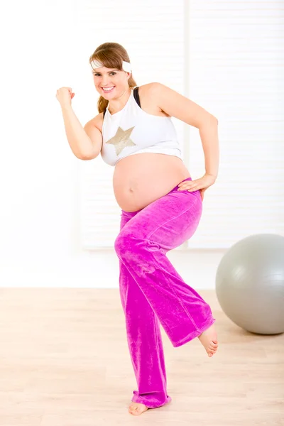 Sonriendo hermosa mujer embarazada haciendo ejercicios de fitness en casa — Foto de Stock