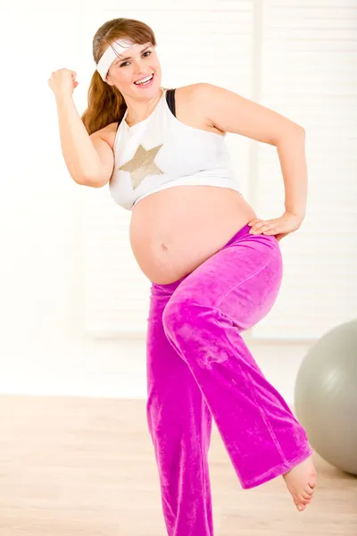 Sonriendo hermosa mujer embarazada haciendo ejercicios de fitness en casa — Foto de Stock