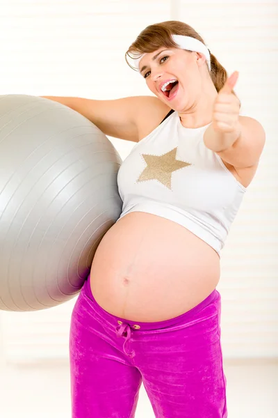 Pregnant female doing pilates exercises on gray ball — Stock Photo, Image